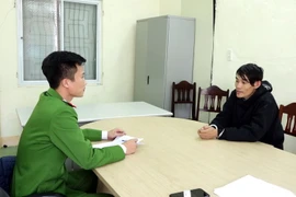 Đối tượng Trần Văn Lợi làm việc với cơ quan Công an. (Ảnh: TTXVN phát)