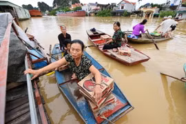 Người dân đến điểm nhận hỗ trợ mỳ tôm, nước uống, bánh mỳ, (Ảnh: Minh Đức/TTXVN)