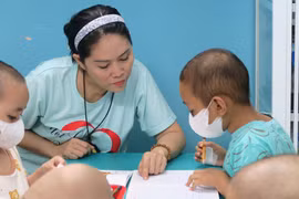Chị Lê Thị Mai, Chủ nhiệm Câu lạc bộ Nét chữ xinh, phụ trách 'Lớp học vui vẻ' đang giảng bài cho học trò. (Ảnh: Đinh Hằng/TTXVN)