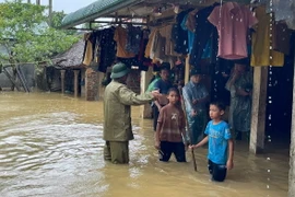 Vận động, hỗ trợ người dân ở những vùng ngập lụt di dời đến nơi an toàn. (Ảnh: TTXVN phát)