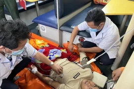 Chăm sóc y tế cho thuyền viên gặp nạn. (Ảnh: TTXVN phát)
