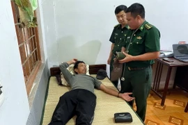 Đại diện Đồn Biên phòng cửa khẩu Cảng Gianh thăm khám sức khỏe thuyền viên Phạm Bá Dung. (Ảnh: TTXVN phát)