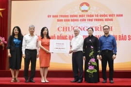 Chủ tịch Ủy ban Trung ương Mặt trận Tổ quốc Việt Nam Đỗ Văn Chiến tiếp nhận bảng tượng trưng số tiền từ Thứ trưởng Bộ Ngoại giao, Chủ nhiệm Ủy ban Nhà nước về người Việt Nam ở nước ngoài Lê Thị Thu Hằng. (Ảnh: TTXVN phát)