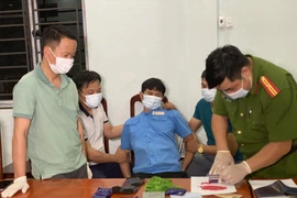 Cán bộ công an kiểm đếm số ma túy. (Ảnh: TTXVN phát)