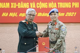 Thượng tướng Nguyễn Chí Vịnh, Thứ trưởng Bộ Quốc phòng trao Quyết định của Chủ tịch nước cho Trung tá Trần Đức Hưởng đi thực hiện nhiệm vụ tại Trụ sở Liên hợp quốc (tại New York, Hoa Kỳ). (Ảnh: Dương Giang/TTXVN)