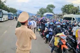 Hàng ngàn người từ Thành phố Hồ Chí Minh trở về quê ùn ứ tại Chốt kiếm soát phòng, chống dịch COVID-19 Cầu 110 (địa phận giữa tỉnh Gia Lai và Đắk Lắk). (Ảnh: Quang Thái/TTXVN)