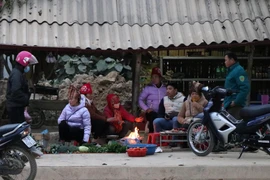 Tại phường Thanh Trường (thành phố Điện Biên Phủ), nhiều tiểu thương tụ tại điểm chợ cóc cạnh quốc lộ 12 tập sưởi ấm bên đống lửa. (Ảnh: Xuân Tiến/TTXVN)