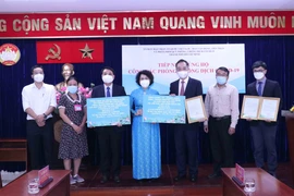 Bà Tô Thị Bích Châu, Chủ tịch Ủy ban MTTQ Việt Nam Thành phố Thành phố Hồ Chí Minh tiếp nhận kinh phí ủng hộ công tác phòng, chống dịch COVID-19 từ ông Ngô Tuấn, Tổng lãnh sự Trung Quốc tại Thành phố Hồ Chí Minh. (Ảnh: Xuân Khu/TTXVN)