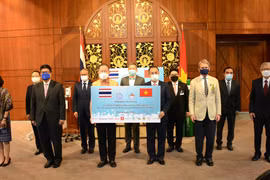 Đại sứ Việt Nam tại Thái Lan Phan Chí Thành (bên phải) tiếp nhận tượng trưng lô hàng vật tư y tế từ ông Sanan Angubolkul, Chủ tịch Hội Hữu nghị Thái Lan-Việt Nam. (Ảnh: TTXVN phát)