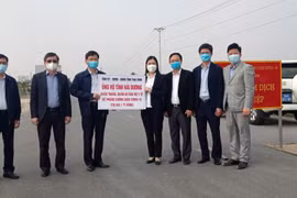 Bà Trần Thị Bích Hằng, Phó Chủ tịch UBND tỉnh Thái Bình cùng lãnh đạo Sở Y tế tỉnh Thái Bình trao tượng trưng số vật tư y tế chuyên dụng phòng, chống dịch COVID-19 cho đồng chí Lương Văn Cầu, Phó Chủ tịch UBND tỉnh Hải Dương. (Ảnh: TTXVN phát)