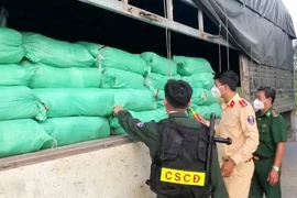 Lực lượng liên ngành kiểm đếm số hàng hóa tạm giữ trên xe tải. (Ảnh: TTXVN phát)