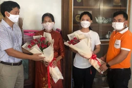 Tổng lãnh sự Việt Nam tại Preah Sihanouk Vũ Ngọc Lý (trái) và đại diện công ty OpenNet chúc mừng hai cô giáo Nguyễn Thị Sương (áo đỏ) và Trần Thị Hoài An. (Ảnh: Trần Long/TTXVN)