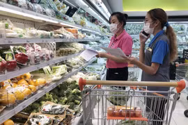 Nhân viên siêu thị giúp người dân đi chợ online tại TP Hồ Chí Minh. (Ảnh: Mỹ Phương/TTXVN)