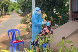 Nhân viên y tế lấy mẫu xét nghiệm sàng lọc SARS-CoV-2 cho người dân xã Quốc Thái, huyện An Phú, An Giang. (Ảnh: Thanh Sang/TTXVN)