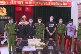 Các đối tượng trong đường dây vận chuyển, mua bán ma túy cùng tang vật vụ án. (Ảnh: Trịnh Duy Hưng/TTXVN)