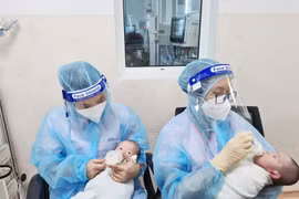 Nhân viên y tế Bệnh viện Nhi Đồng TP. Hồ Chí Minh chăm sóc trẻ có cha, mẹ là F0. (Nguồn: baodantoc.vn)
