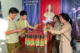 Đội Quản lý thị trường số 2 (Cục Quản lý thị trường tỉnh Kon Tum) kiểm tra các sản phẩm rượu giả nhãn mác thương hiệu rượu sâm Ngọc Linh Kon Tum K5. (Ảnh: TTXVN)