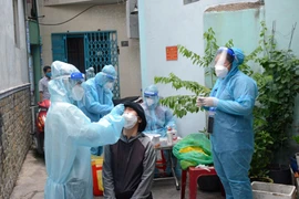 Tổ công tác Học viện Quân y phối hợp cùng địa phương lấy mẫu tầm soát COVID-19 tại phường 9, Quận 8, Tp. Hồ Chí Minh. (Ảnh: Thanh Vũ - TTXVN)