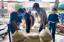 Cấp phát gạo cho người dân gặp khó khăn do ảnh hưởng dịch COVID-19. (Ảnh: Thu Hiền/TTXVN)