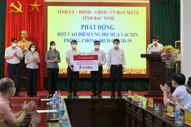 Đại diện lãnh đạo tỉnh Bắc Ninh tiếp nhận 2 tỷ đồng của Ngân hàng Nông nghiệp và Phát triển nông thôn chi nhánh Bắc Ninh. (Ảnh: Thái Hùng/TTXVN)