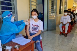Tiêm vaccine cho thiếu niên từ 16 đến 17 tuổi tại xã Lộc Quang, huyện biên giới Lộc Ninh, Bình Phước. (Ảnh: TTXVN phát)