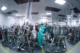 Nhân viên làm việc tại dây chuyền sản xuất vaccine ngừa COVID-19 của công ty dược phẩm Sanofi ở Val-de-Reuil, Pháp ngày 10/7/2020. (Ảnh: AFP/TTXVN)