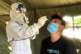 Nhân viên y tế lấy mẫu test nhanh cho các thuyền viên. (Ảnh: Lê Ngọc Phước/TTXVN)