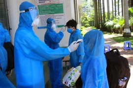 Đo thân nhiệt cho người lao động và thân nhân từ Bắc Giang trở về tại Khu cách ly tại trường Đại học Thái Bình tháng 6/2021. (Ảnh: Thế Duyệt/TTXVN)