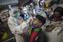 Nhân viên y tế lấy mẫu xét nghiệm COVID-19 cho người dân tại Surabaya, Indonesia ngày 17/6/2021. (Ảnh: AFP/TTXVN)