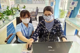 Hướng dẫn khách hàng giao dịch thanh toán tiền điện tại các chi nhánh điện lực của EVNCPC. (Ảnh: TTXVN phát)