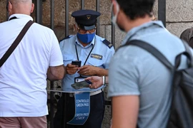 Nhân viên an ninh kiểm tra chứng nhận COVID-19 của khách tham quan tại Rome, Italy, ngày 6/8/2021. (Ảnh: AFP/TTXVN)