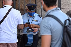 Nhân viên an ninh kiểm tra chứng nhận COVID-19 của khách tham quan tại Rome, Italy, ngày 6/8/2021. (Ảnh: AFP/TTXVN)