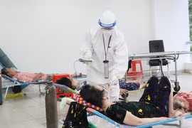 Các bác sỹ thăm khám bệnh nhân nhiễm COVID-19 không triệu chứng có bệnh nền tại Bệnh viện dã chiến thu dung điều trị COVID-19 số 3, thành phố Thủ Đức. (Ảnh: Xuân Khu-TTXVN)