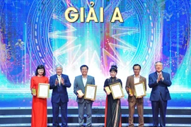 Ông Đỗ Văn Chiến, Bí thư Trung ương Đảng, Chủ tịch UBTƯ MTTQ Việt Nam và ông Nguyễn Hòa Bình, Ủy viên Bộ Chính trị, Bí thư Trung ương Đảng, Chánh án Tòa án nhân dân Tối cao trao giải A cho 4 tác giả, nhóm tác giả. (Ảnh: Minh Đức/TTXVN)