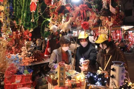 Người dân mua sắm đồ Giáng sinh 2021 trên phố Hàng Mã. (Ảnh: Hoàng Hiếu/TTXVN)