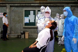 Đơn vị chức năng lấy mẫu xét nghiệm COVID-19 cho công nhân Công ty thiết bị nhà bếp VINA, tại Khu công nghiệp Tân Bình. (Ảnh: TTXVN phát)