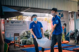 Thanh niên tình nguyện vận chuyển gạo, lương thực cho những hộ dân thuộc khu vực phong tỏa trên địa bàn quận Tân Phú. (Ảnh: Hồng Giang/TTXVN)