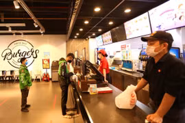 Các cửa hàng ăn, uống trong TTTM BigC Thăng Long (Hà Nội) yêu cầu khách hàng đứng giãn cách và chỉ bán hàng mang về. (Ảnh: Hoàng Hiếu/TTXVN)