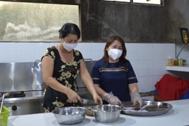 Chị Lê Thị Thanh Hương (phải) tổ chức nấu và cung cấp miễn phí hơn 90.000 suất ăn cho lực lượng tham gia chống dịch, người trong khu phong tỏa, cách ly. (Ảnh: Nhựt An/TTXVN)