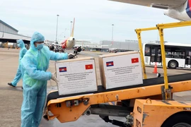 Vận chuyển hàng hỗ trợ của Chính phủ và nhân dân Campuchia từ máy bay ra xe hàng hóa hàng không chuyên dụng. (Ảnh: Xuân Khu-TTXVN)