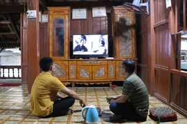 Người dân xã Mường Phăng xem những thước phim về cuộc đời, quá trình hoạt động cách mạng của Đại tướng Võ Nguyên Giáp. (Ảnh: Xuân Tiến/TTXVN)