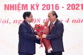 Thủ tướng Phạm Minh Chính tặng hoa chúc mừng Chủ tịch nước Nguyễn Xuân Phúc. (Ảnh: Dương Giang/TTXVN)