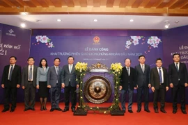 Bộ trưởng Bộ Tài chính Đinh Tiến Dũng và các đại biểu dự Lễ đánh cồng khai trương phiên giao dịch đầu năm 2021. (Ảnh: Phạm Hậu/TTXVN)