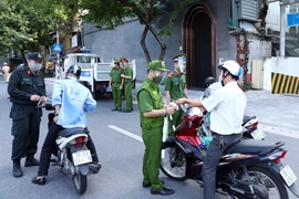 Lực lượng Công an Hà Nội kiểm tra giấy tờ người tham gia giao thông tại chốt liên ngành tuyến phố Trần Quang Khải (quận Hoàn Kiếm). (Ảnh: Phạm Kiên/TTXVN)