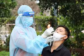 Lấy mẫu xét nghiệm sàng lọc COVID-19. (Ảnh: Tuấn Anh/TTXVN)