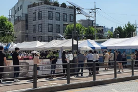 Người dân xếp hàng xét nghiệm COVID-19 trong thời tiết nắng nóng ở quận Seongbuk, Seoul. (Ảnh: Mạnh Hùng/TTXVN)