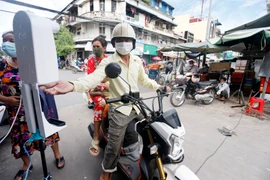 Người dân sát khuẩn tay phòng dịch COVID-19 tại một khu chợ ở Phnom Penh, Campuchia, ngày 11/10/2021. (Ảnh: THX/TTXVN)