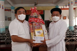 Chủ tịch Ủy ban Mặt trận Tổ quốc Việt Nam tỉnh, Trưởng ban Dân vận tỉnh Cà Mau Trần Văn Hiện (trái) tặng quà chúc mừng chức sắc, chức việc Hội thánh Cao đài Minh Chơn Đạo (ấp Xóm Sở, xã Hồ Thị Kỷ, huyện Thới Bình). (Ảnh: Kim Há/TTXVN)