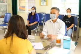 Ngành Lao động-Thương binh và Xã hội phối hợp với các sở, ngành chức năng và phường, xã chi trả hỗ trợ cho người bị ảnh hưởng do dịch COVID-19. (Ảnh: Hoàng Hiếu/TTXVN)