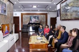 Người Việt tại Lào tập trung theo dõi lễ khai mạc Đại hội Đảng XIII. (Ảnh: Phạm Kiên/TTXVN)